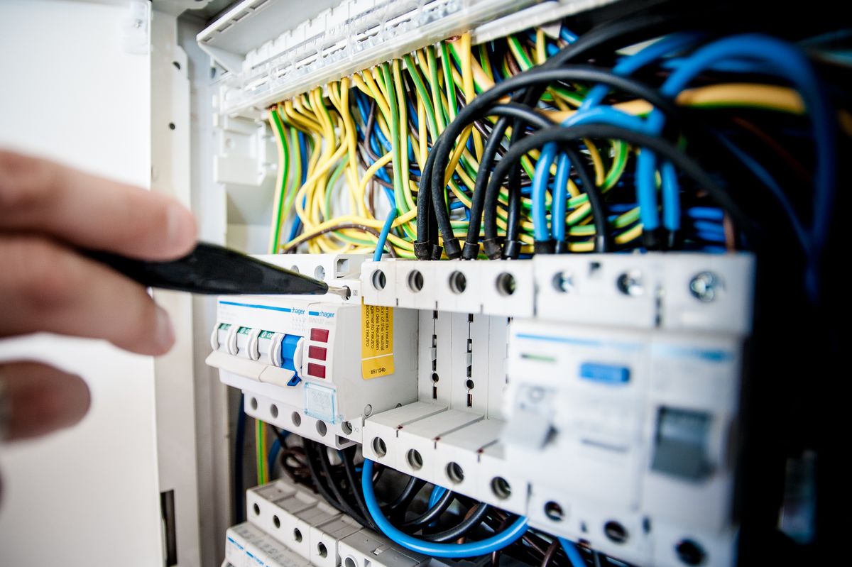 Electrical wiring and circuit breakers being inspected during a repair