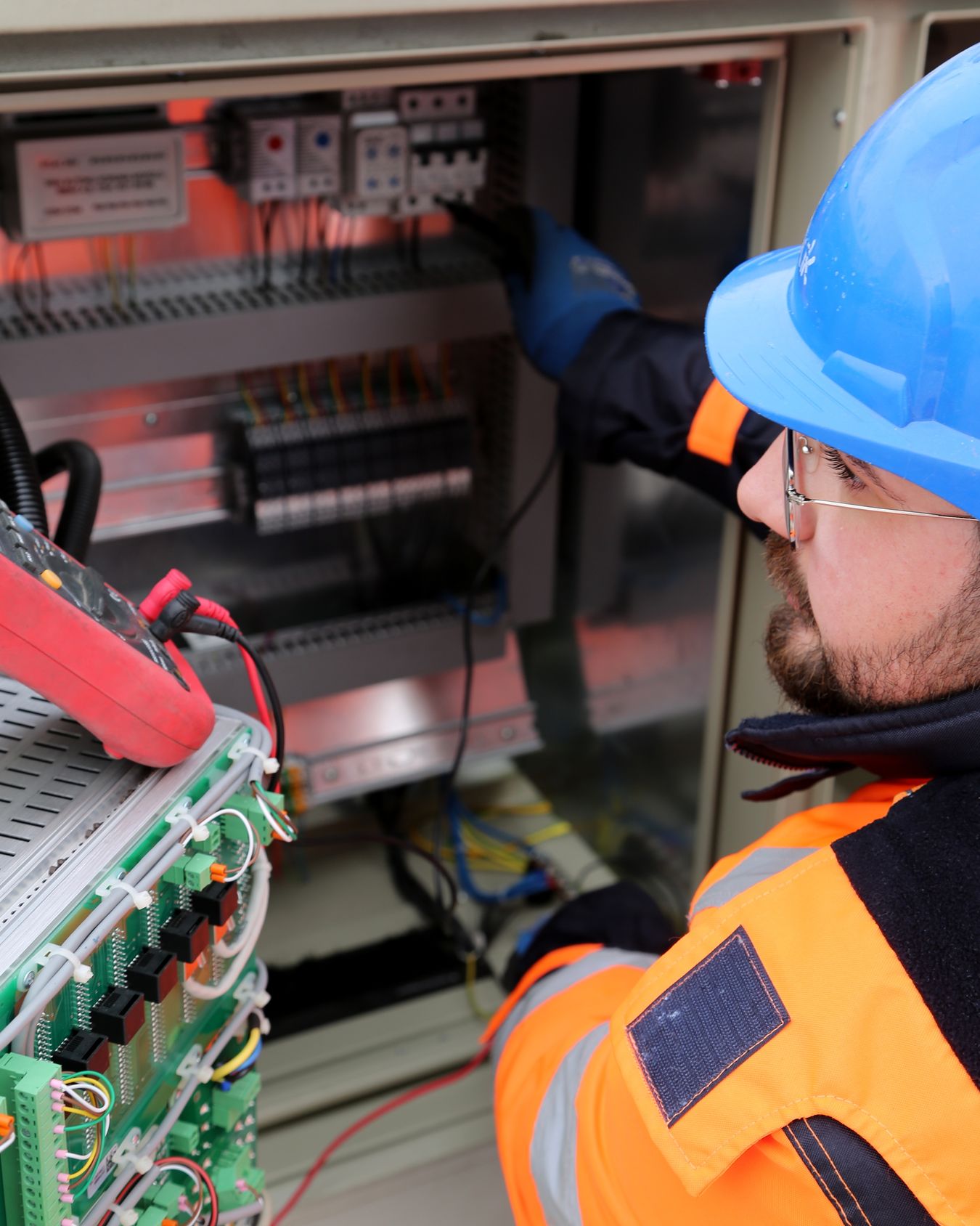 Professional electrician inspecting an electrical control panel